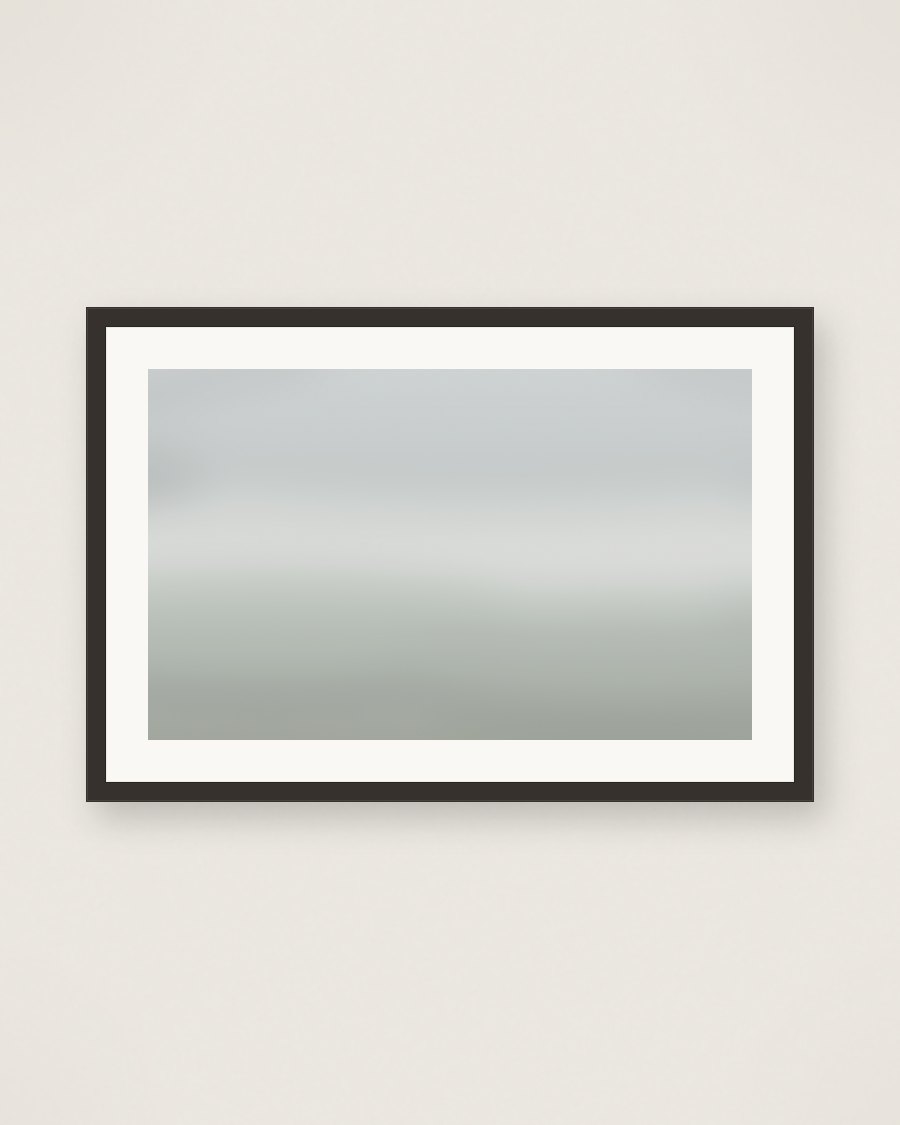 Framed pale fog color-field over muted fields, charcoal frame and cream mat
